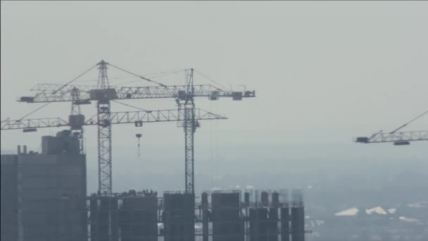 Grúas de torre y constructores que trabajan en la construcción del edificio
 - Metraje, vídeo