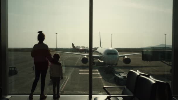Mother with daughter wait for departure in airport - Záběry, video