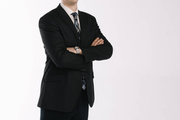 portrait of a businessman standing on a white background with folded hands - Zdjęcie, obraz