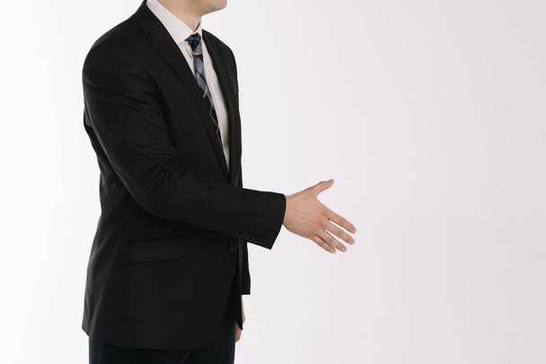 portré egy üzletemberről, aki fehér háttéren áll kinyújtott kézzel - Fotó, kép