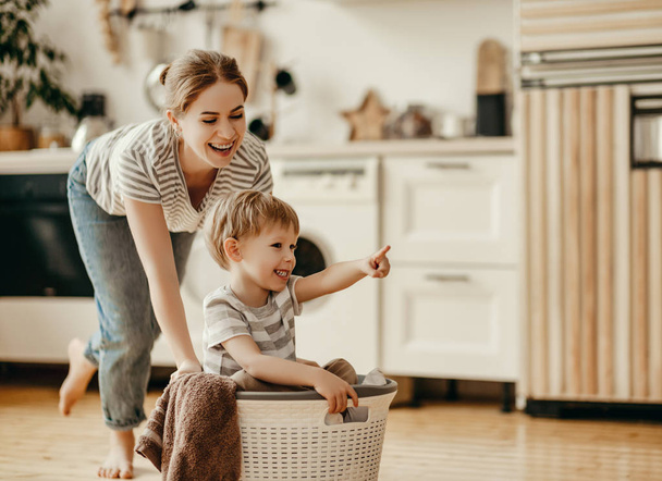 glückliche Familienmutter Hausfrau und Kind Sohn in Wäscherei mit Waschmaschine - Foto, Bild