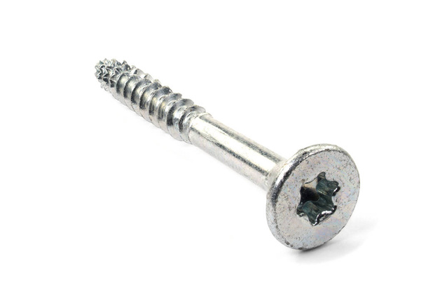 Torx screws on white background close up. Silver screws for wood, chipboard or plywood with torx head. - Foto, Bild