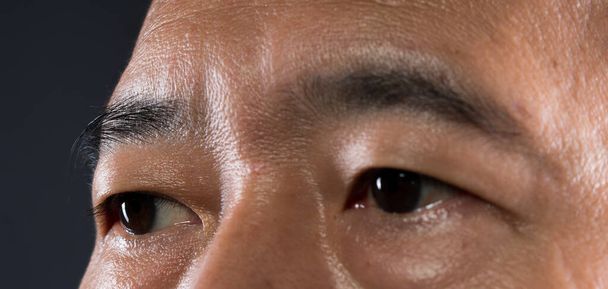 Gros plan macro portrait de l'œil de l'homme, Homme yeux bruns ouverts avec maquillage beauté jour. Homme d'âge moyen 40 ans avec une peau parfaite de verrue d'acné et des taches de rousseur profondes
. - Photo, image