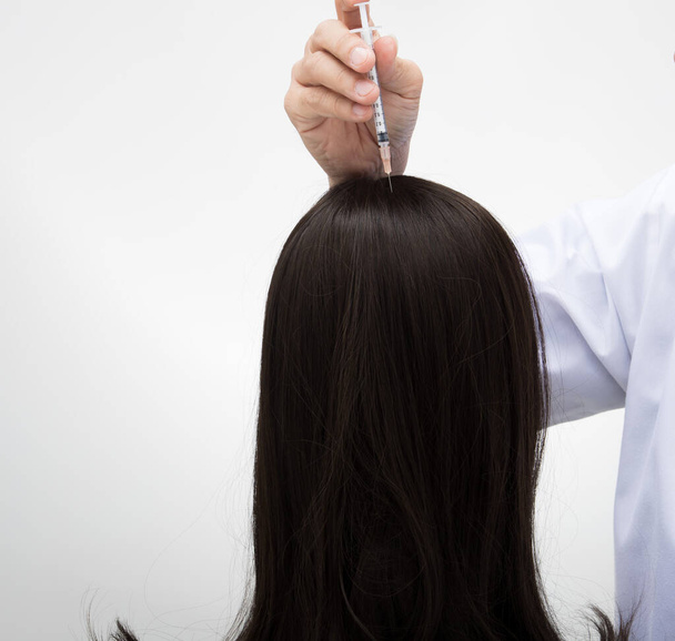 Estetyka Lekarz wstrzyknąć leczenie witaminy surowicy do włosów spadek obszaru na głowie przez strzykawkę, Black Hair Loss klinika terapeutyczna, aby zapobiec upadkowi w pracy seniora kobieta, oświetlenie studio izolowane - Zdjęcie, obraz