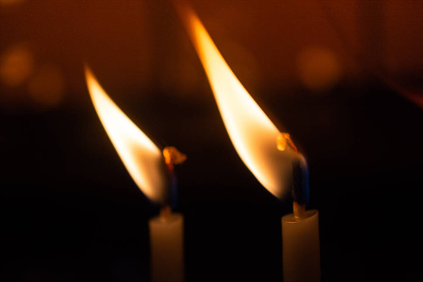 Τα κεριά λάμπουν στο σκοτάδι. Αφηρημένο φόντο κεριά. Ελπίδα, φωτιά. - Φωτογραφία, εικόνα