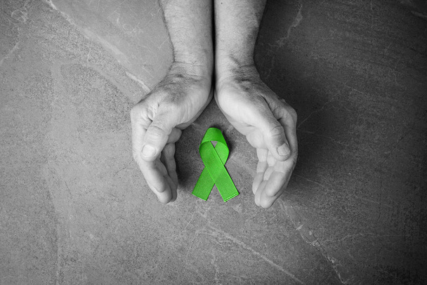手は緑のリボンを保持します,リンパ腫癌 - 写真・画像