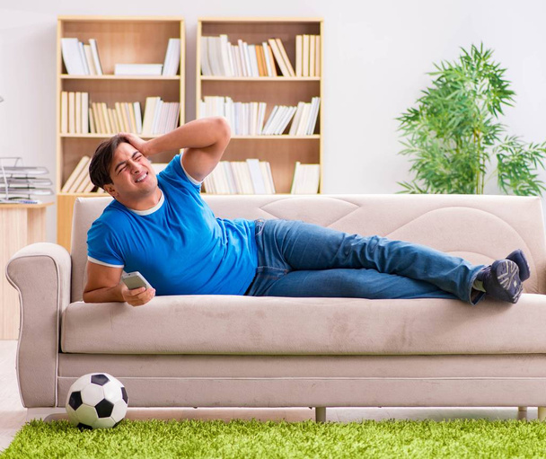 Man watching football at home sitting in couch - Foto, Imagem