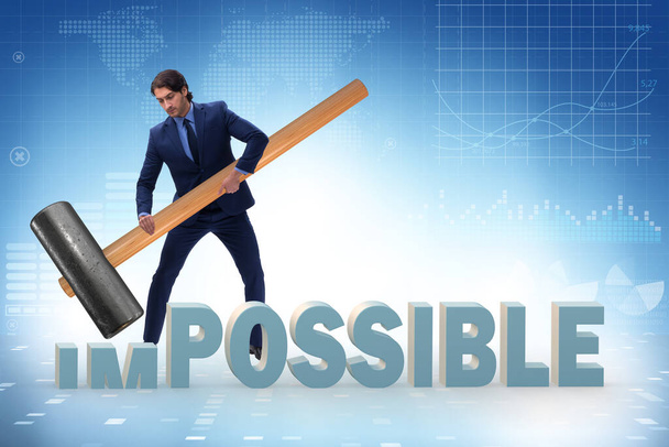 Бизнесмен бьет молотком по слову "невозможно"
 - Фото, изображение