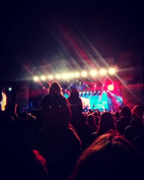 dav lidí na koncertě, rodinný koncert s mnoha světly s červenými a bílými tóny a mnoho lidí - Fotografie, Obrázek