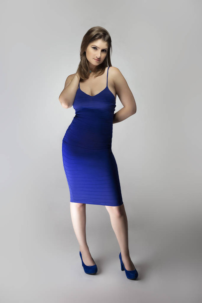 Catalogue style studio photo d'une mannequin blanche portant une robe d'été bleu marine ou bleu royal. Elle pose pour montrer le style à la mode de la tenue ou des vêtements
 - Photo, image