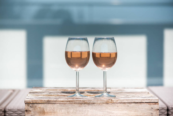 Two rose wine glasses on a small wooden table - Photo, Image