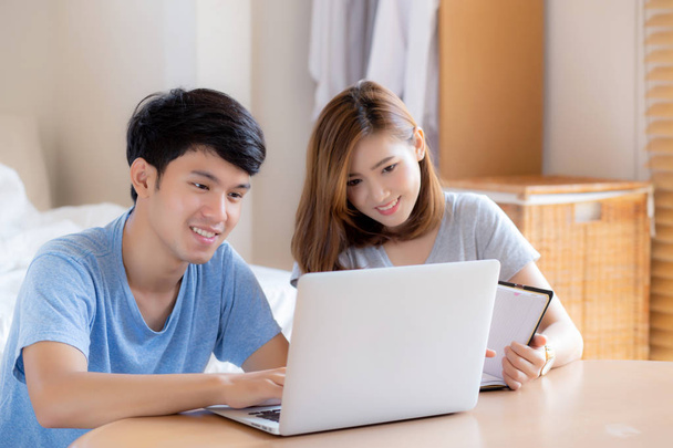 Gyönyörű fiatal ázsiai pár kiszámítani költségek pénzügy laptop és tervezés együtt, nő írás notebook vagy megjegyzés költségvetési háztartás, életmód család és üzleti koncepció. - Fotó, kép
