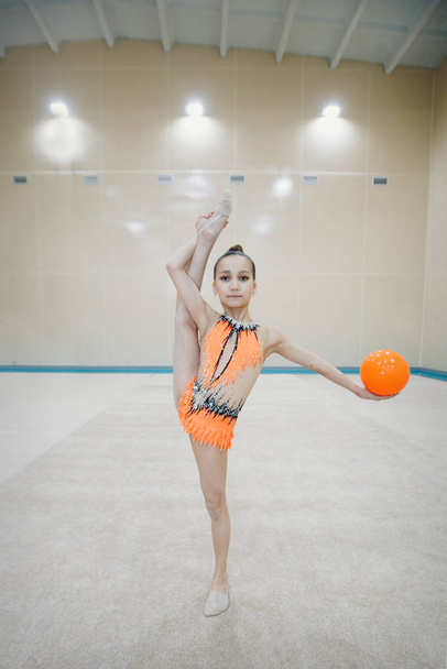 A girl in a tracksuit doing exercises with ball on a white background. Healthy lifestyle concept, sports uniforms, world Cup, gym, specialized clothing, uniforms - 写真・画像