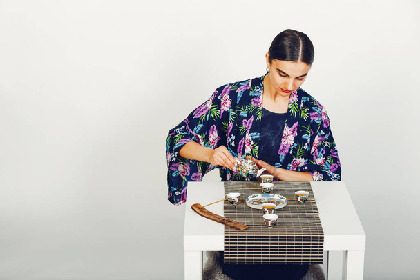 Beautiful girl drinking a tea in a studio - Fotoğraf, Görsel