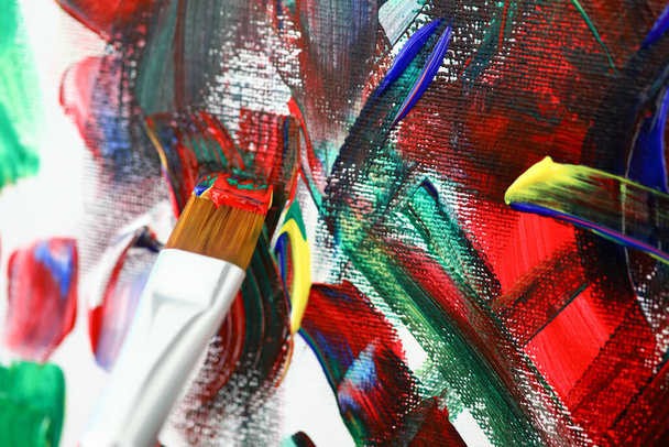 Brush with acrylic paint on background of art canvas - Foto, Imagem