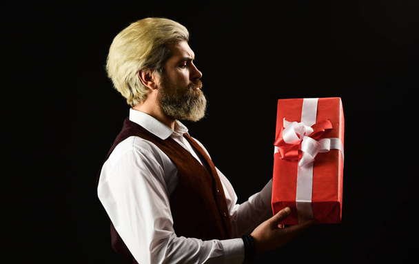 for me. Typically used for birthday or anniversary presents. boxing day and shopping concept. romantic gift for boyfriend. gift box on black background in male hand. creating a romantic atmosphere - Фото, изображение