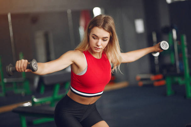 Sports blonde in a sportswear training in a gym - Foto, Imagem