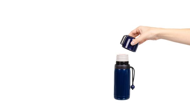 Hand with dark blue thermos with mug. Isolated on white background. Copy space, template. - Фото, зображення