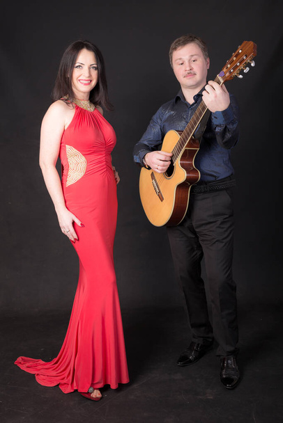 portrait of a woman in a red dress and a guitarist - Photo, Image