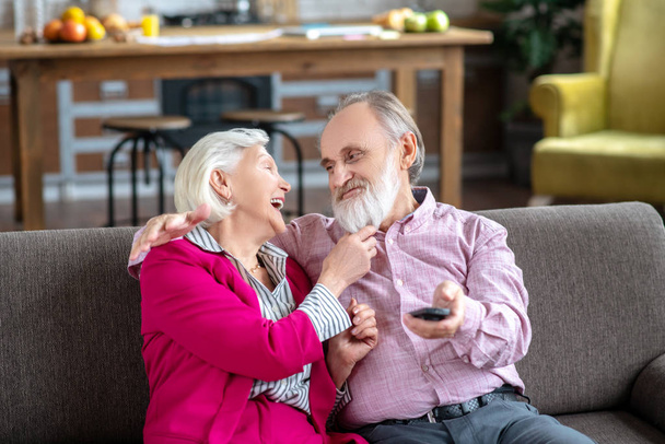 Grey-haired smiling woman touching her husbands beard - Foto, Bild