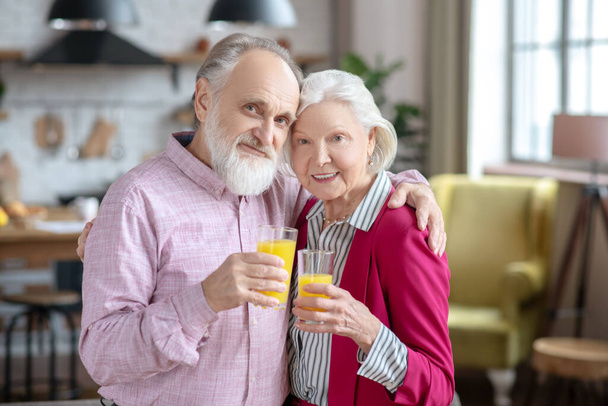 Married senior couple having orange juice and feeling good - Zdjęcie, obraz