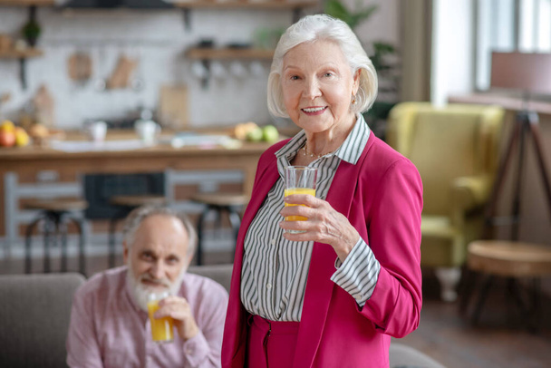 Married senior couple having orange juice together - Foto, Imagen