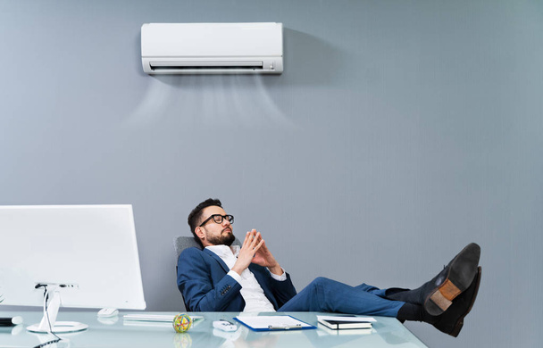 Relaxed Businessman Enjoying The Cooling Of Air Conditioner In The Office - Photo, image