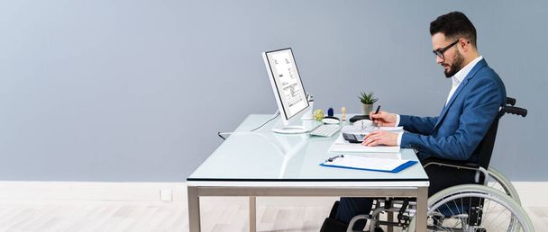 Businessman Sitting On Wheelchair And Using Computer - Фото, изображение