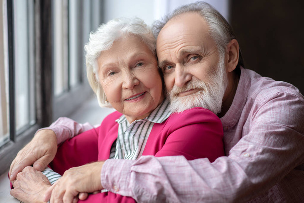 Imagen de cerca de una pareja de ancianos abrazados de pelo gris
 - Foto, Imagen