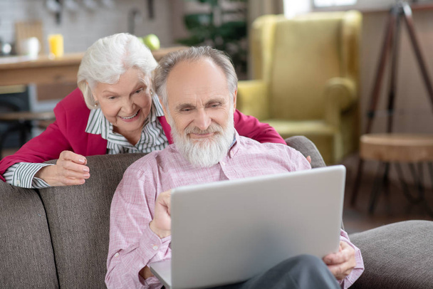 Vanhempi aviopari hymyilee videopuhelun aikana
 - Valokuva, kuva