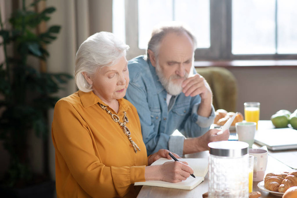 Elderly married couple sitting at the table making calculations - Foto, afbeelding