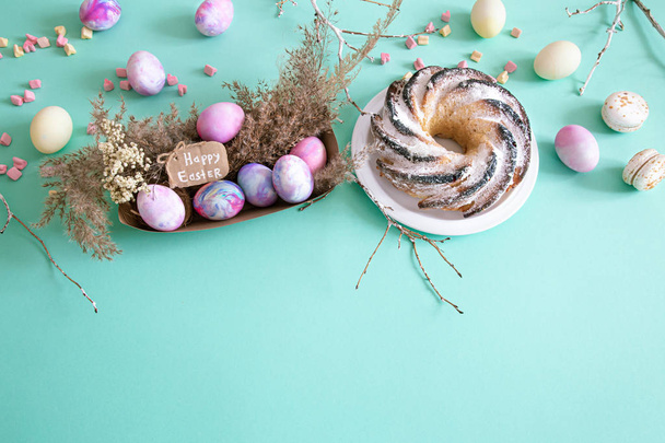 Renkli arkaplanda yumurta ve kek olan Paskalya kompozisyonu. Paskalya tatili konsepti. - Fotoğraf, Görsel