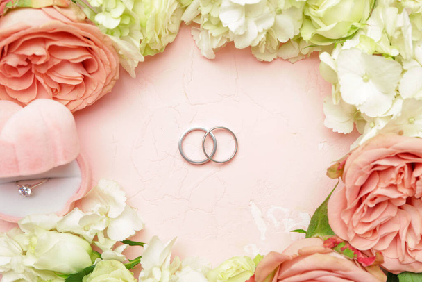 Krásné svatební prsteny s květinami na barevném pozadí - Fotografie, Obrázek