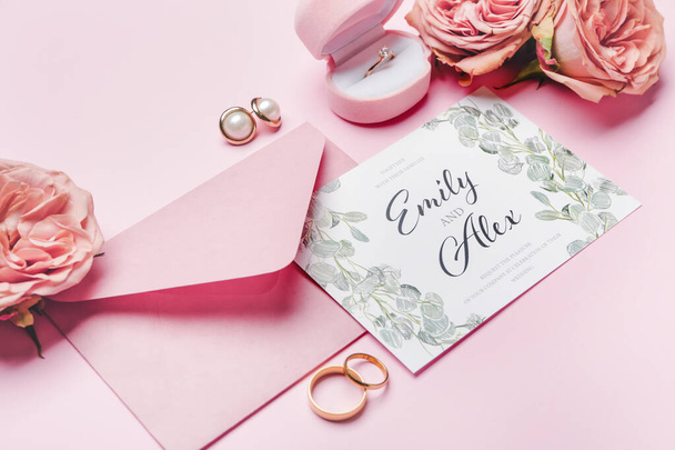 Beautiful composition with wedding invitation and jewelry on color background - Fotó, kép