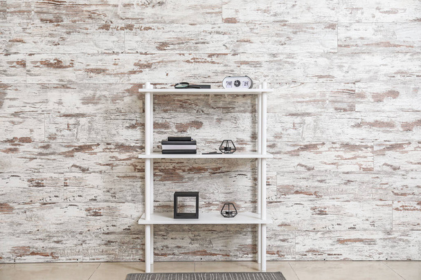 Modern shelf unit near wooden wall - Foto, imagen