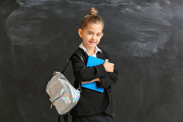 Cute little schoolgirl near blackboard in classroom - Photo, image