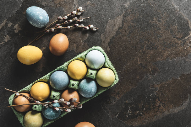 Easter background with space for a text. Natural dyed easter eggs on dark stone background. - Фото, зображення