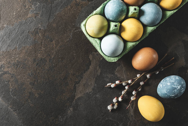 Easter background with space for a text. Natural dyed easter eggs on dark stone background. - Foto, Imagen