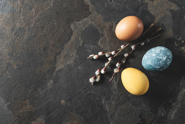 Easter background with space for a text. Natural dyed easter eggs on dark stone background. - Photo, Image