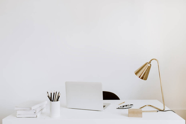 Escritório com laptop, lâmpada, cadernos. Armário de estudo de trabalho branco. Outsourcing freelancer, blogger, boss workspace
. - Foto, Imagem