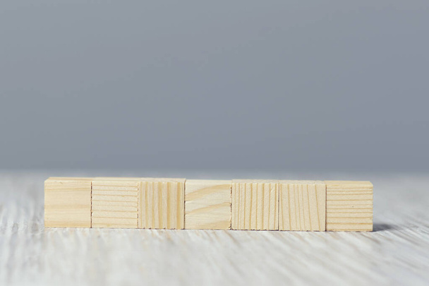 figuras quadradas de madeira em linha sobre um fundo cinza
 - Foto, Imagem