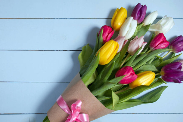 A bouquet of color tulips on the floor. A gift to a women day. Spring tulips flowers background - Foto, Imagem