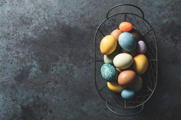 Easter background. Homemade natural diyed easter eggs in a basket and space for a text - Photo, image