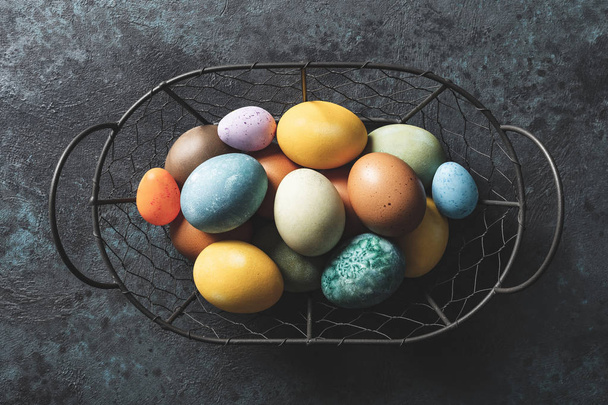Homemade natural diyed easter eggs in a basket - 写真・画像