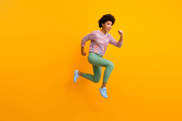 Full size profile side photo of cheerful crazy funny afro american girl jump run fast hurry after black friday discount wear stylish green outfit isolated over shine bright color background - Foto, imagen