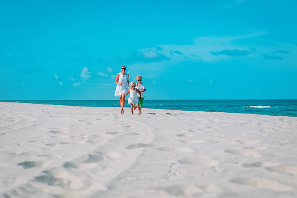mère avec enfants jouer, course familiale sur la plage tropicale - Photo, image
