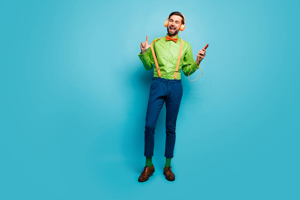 Full length body size view of his he nice attractive dreamy cheerful cheery guy listening playlist hit songs isolated on bright vivid shine vibrant blue green teal turquoise color background - Foto, Imagem