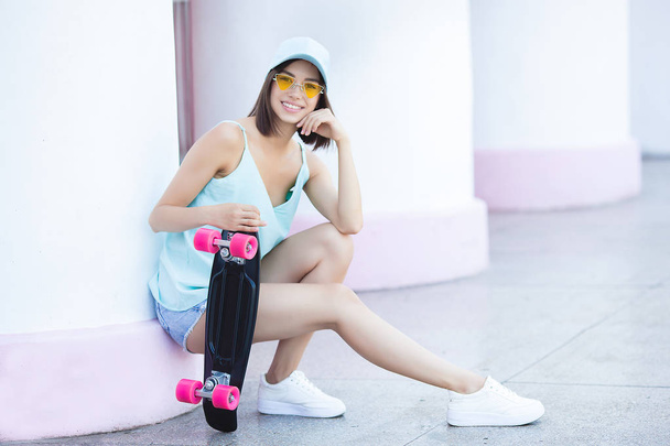 若い魅力的な女性屋外スケート.屋外でかなり女性の肖像画.スケートと笑顔を保持するブルネットの女性。アクティブ・ユース. - 写真・画像