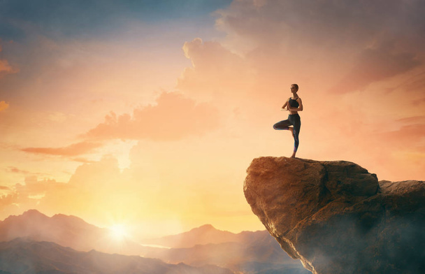 Woman is practicing yoga and meditates on the mountain. - Photo, Image