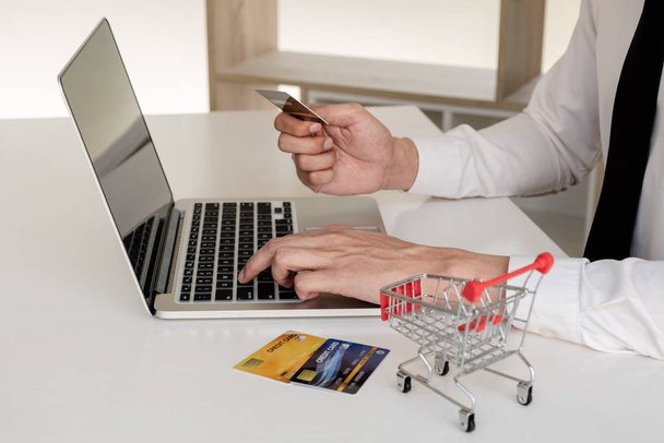 Biznesmeni używają kart kredytowych i laptopów do zakupów online i dokonywania płatności interne. - Zdjęcie, obraz